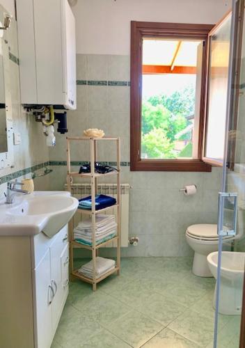 a bathroom with a sink and a toilet and a window at Edera in Porto Corsini