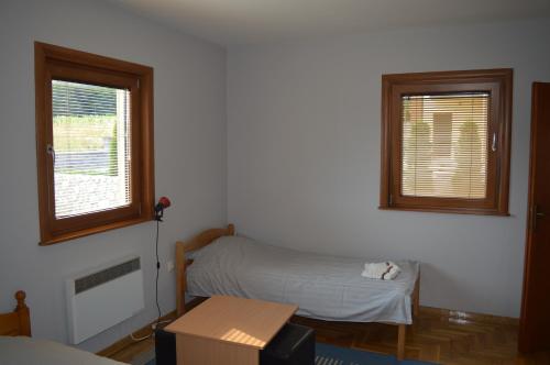 a small room with a bed and two windows at Apartment Nadja in Zlatibor