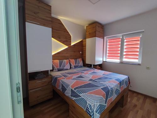 a bedroom with a bed with a wooden headboard at Sky Apartments in Strumica