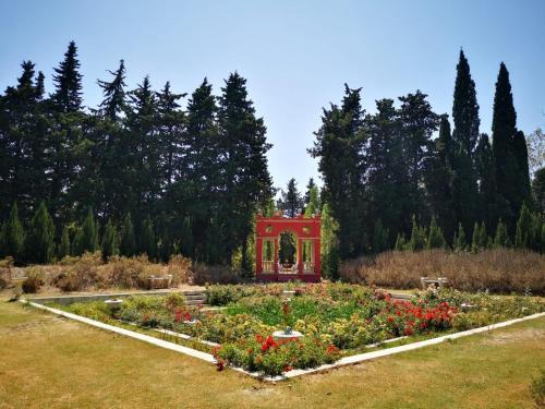 a garden with a red structure in the middle at Mas de la Chapelle in Arles