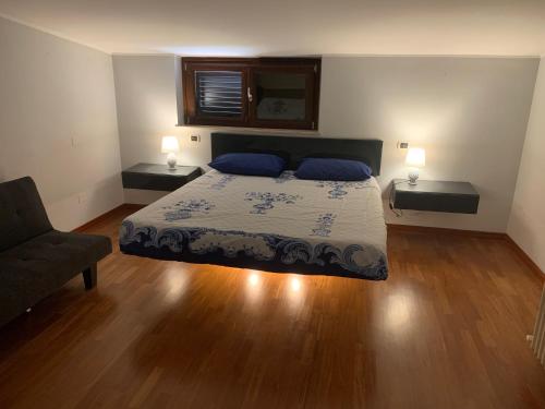 a bedroom with a bed and a chair and two lamps at Attico The View in Pescara