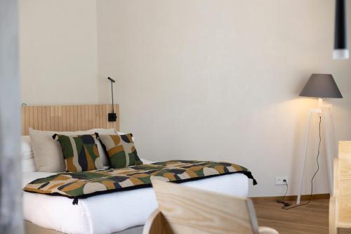 a bedroom with a bed and a lamp in it at A SPERANZA Suites avec piscine privative chauffée in Bonifacio