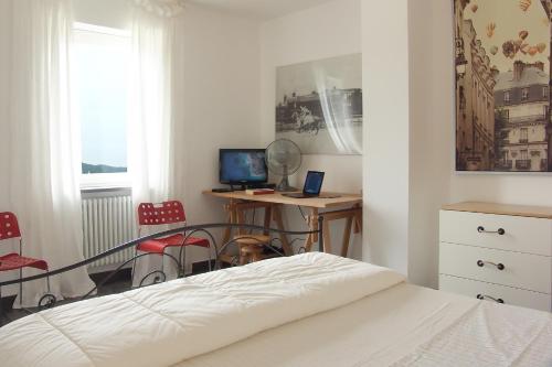 a bedroom with a bed and a desk with a computer at Luxury Easy Living in Framura in Framura