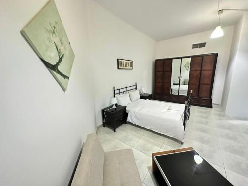 a bedroom with a bed and a table and a window at Comfortable Private Rooms in Compound Housing in Dubai