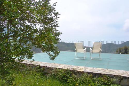 two chairs sitting on top of a swimming pool at Luxury Easy Living in Framura in Framura