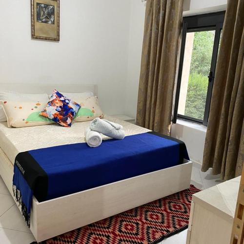 a bedroom with a bed with blue sheets and a window at MetaB&B in Gusmar