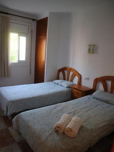 two beds in a room with two towels on them at Acogedor apartamento en l'Estartit in L'Estartit