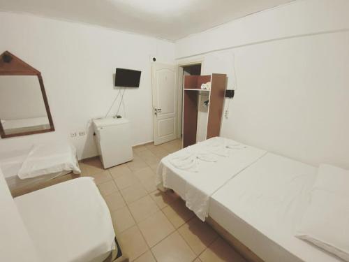 Habitación de hotel con 2 camas y TV en DENGE PANSİYON, en Datça