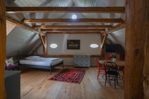 a bedroom with a bed and a table in a attic at Mlýn Salajna in Dolní Žandov