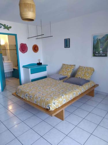 a bed in a room with a blue table at STUDIO MI AIME AOU in La Saline les Bains
