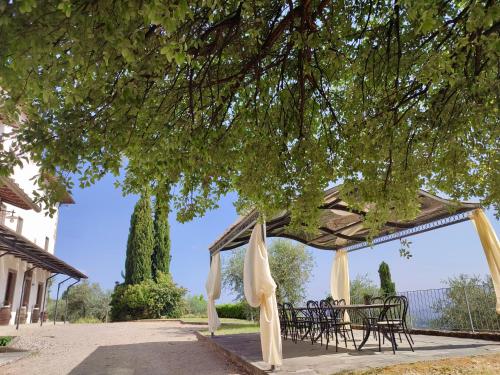 a table and chairs under a pavilion under a tree at Agriturismo Cafaggio Primo in Loro Ciuffenna