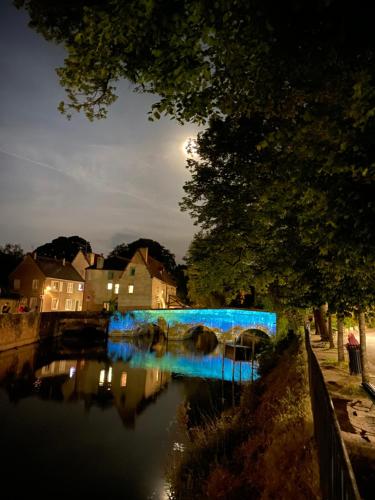 un pont bleu sur une rivière la nuit dans l'établissement L'ATELIER 14 - Centre ville - Appartement entier- Neuf, à Chartres