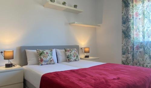 a bedroom with a bed with a pink blanket and two lamps at Pinea 12 D in Vilacolum