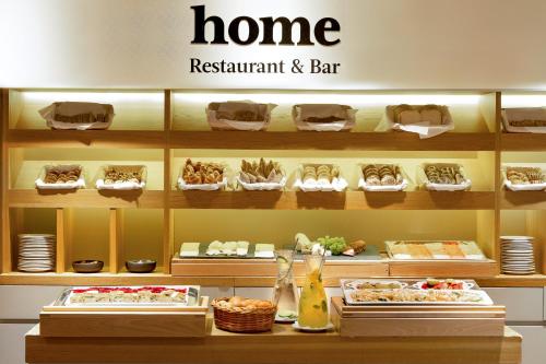 a home restaurant and bar with a shelf of food at INNSiDE by Meliá Prague Old Town in Prague