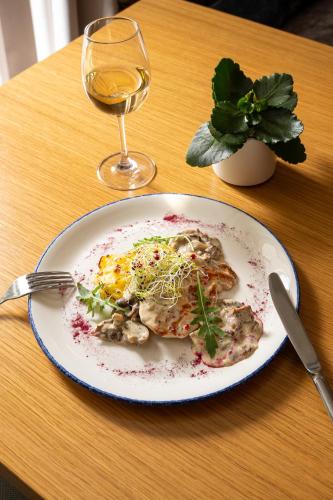 a plate of food on a table with a glass of wine at INNSiDE by Meliá Prague Old Town in Prague