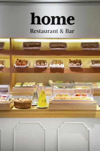 a home restaurant and bar sign on a counter with food at INNSiDE by Meliá Prague Old Town in Prague