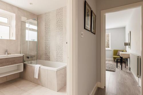 ein Badezimmer mit einer Badewanne, einem Waschbecken und einem Spiegel in der Unterkunft Middle Chine in Bournemouth