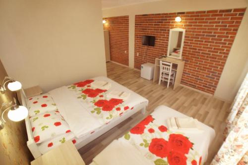 Habitación pequeña con 2 camas y pared de ladrillo en Hotel Divna en Krumovgrad
