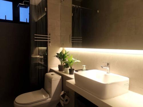 La salle de bains est pourvue d'un lavabo, de toilettes et d'un miroir. dans l'établissement The Shore Artsy Studio Kota Kinabalu, à Kota Kinabalu