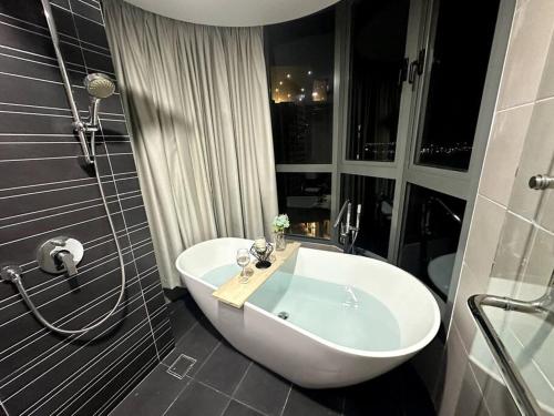 a bathroom with a white tub and a shower at Teega Modern 4BR 12pax pooltable by Our Stay in Nusajaya