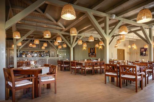 un ristorante con tavoli e sedie in legno e un bar di Green Village Resort a Sfântu Gheorghe
