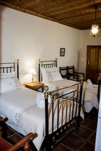 two twin beds in a bedroom with a wooden ceiling at The Vale Karoo Farm in Nelspoort