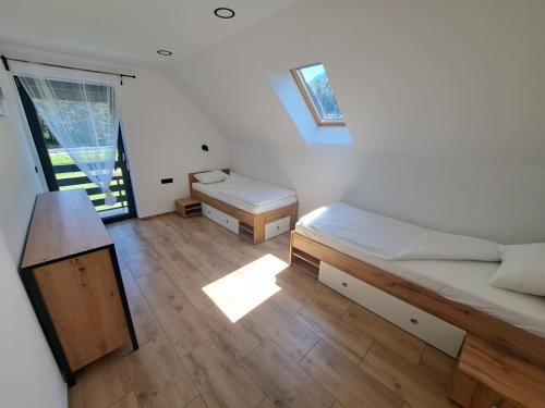 una piccola camera con due letti e una finestra di Riverside Apartma 1, Kranjska Gora a Kranjska Gora