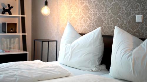 Lehmen的住宿－Casa Mo - Ferienwohnung Lehmen，一张带白色床单和枕头的床