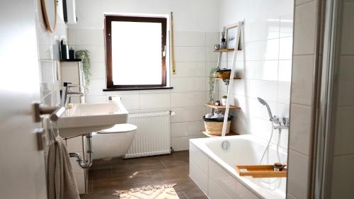 Lehmen的住宿－Casa Mo - Ferienwohnung Lehmen，浴室配有盥洗盆、卫生间和浴缸。