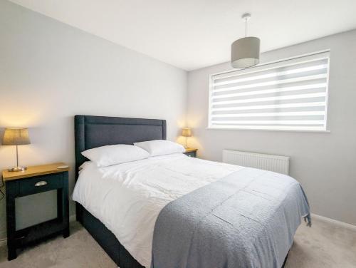 a bedroom with a large bed and a window at Brook House - Emsworth in Emsworth
