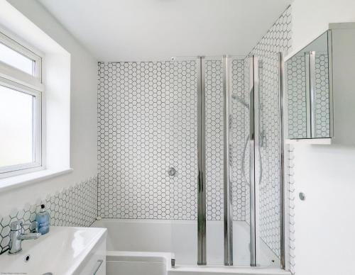 a white bathroom with a shower and a sink at Brook House - Emsworth in Emsworth