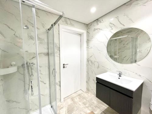 a bathroom with a shower and a sink and a mirror at Casinha no caminho de Santiago in Belinho