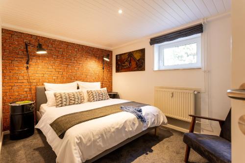 1 dormitorio con cama y pared de ladrillo en Harley in der Heide, en Buchholz - Aller