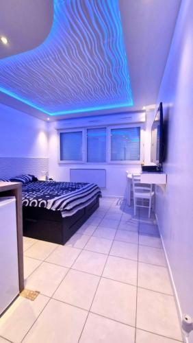 a bedroom with a bed and a desk and a television at Bron centre appartement meublé avec jacuzzi in Bron