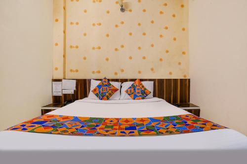 um quarto com uma cama com um edredão colorido em FabExpress Swara Residency em Bārāmati