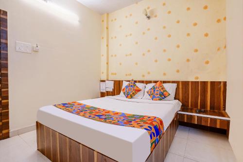 ein Schlafzimmer mit einem Bett in einem Zimmer in der Unterkunft FabExpress Swara Residency in Bārāmati