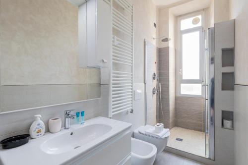 a white bathroom with a sink and a toilet at I Host Apartment - Asiago 4 in Milan