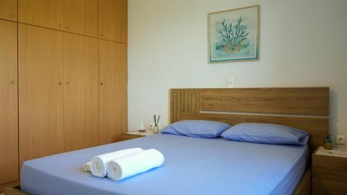 a bedroom with a bed with two towels on it at Urban Blue House in Agios Nikolaos