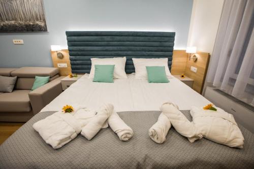 a bedroom with a large bed with towels on it at Klečka vila B&B rooms in Ogulin