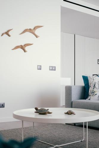 a living room with a white coffee table and birds at Orange Boutique Residence - Casa Diogo in Quarteira
