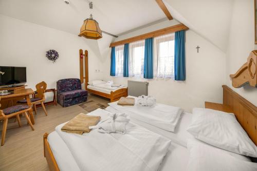 a bedroom with two beds and a desk and a room at Waldschlössl Gasthof in Sankt Lorenzen ob Murau