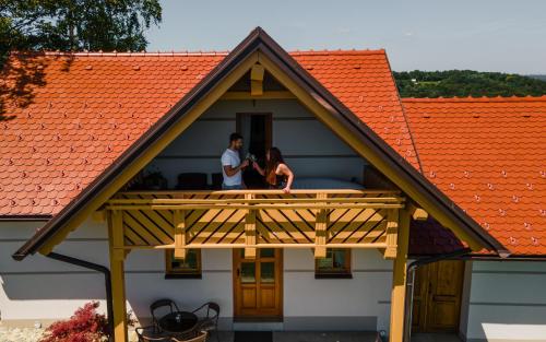 a man and woman standing on a balcony of a house at Villa VINEYARD in Velika Nedelja
