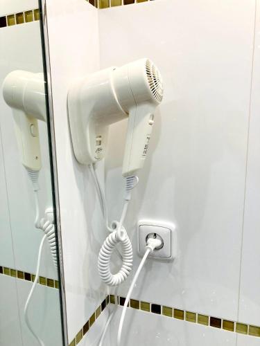 a hair dryer is attached to a wall in a bathroom at Hotel U Ševce in Zlín