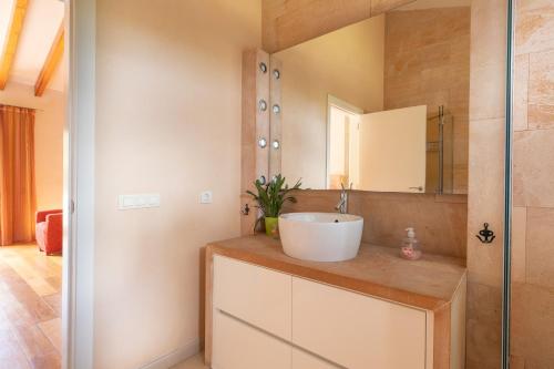 een badkamer met een wastafel en een spiegel bij La Forca in Santa Margalida