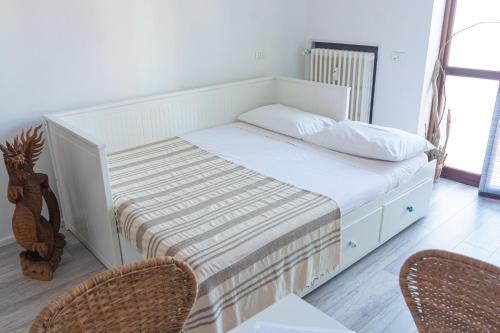 białe łóżko z 2 krzesłami w pokoju w obiekcie Casetta Azzurra w mieście Pero
