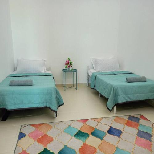 2 letti posti in una stanza con tappeto di Rumah Pantai de Merabang 2 (Seaview Homestay) a Bachok