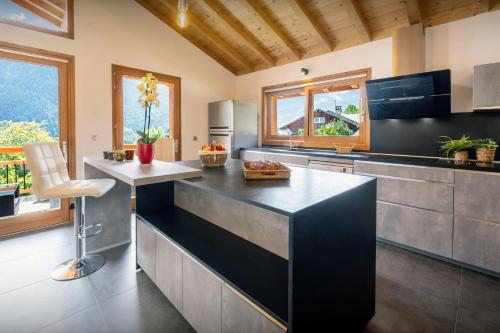 a kitchen with a black counter top in a room at Les Moulins D'Angelina - OVO Network in Séez
