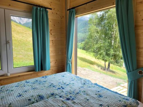 a bedroom with a bed and a large window at Tinyhaus Villa to go in Reichenau