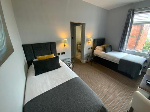 a hotel room with two beds and a mirror at Wheldale Hotel in Castleford