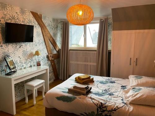une chambre avec un lit, un bureau et une télévision dans l'établissement Ty Glaz, à Quimper